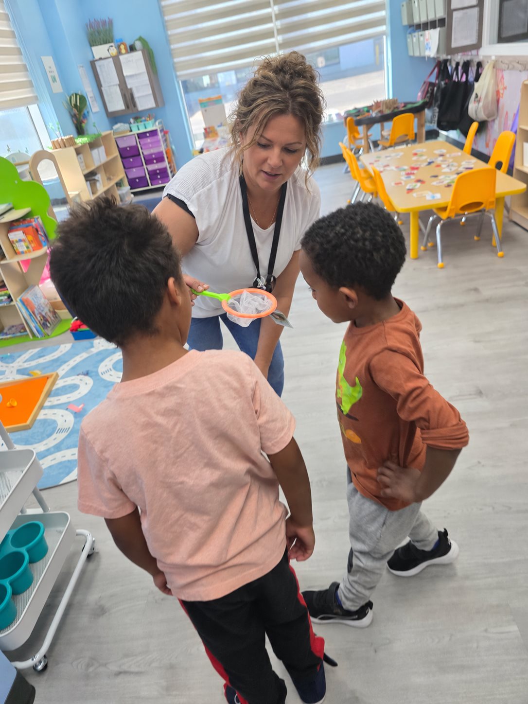 An educator guiding two children through a classroom activity
